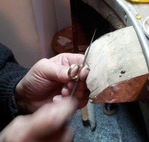 Artigiano orafo rifinitura anello con lima triangolare
