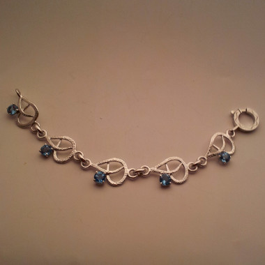 Bracciale con motivi ornamentali in oro bianco e topazi azzurri
