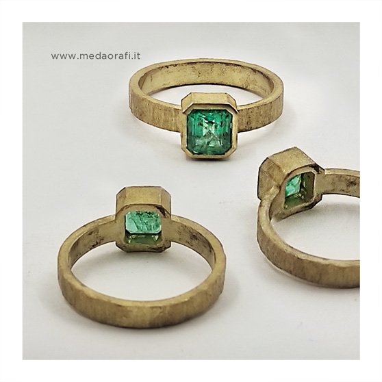 Tre viste dell'anello in oro giallo e smeraldo, versione con castone quadrato