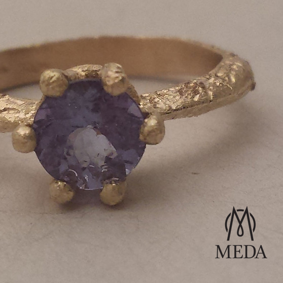 Anello solitario in oro giallo con tanzanite viola particolare delle griffe