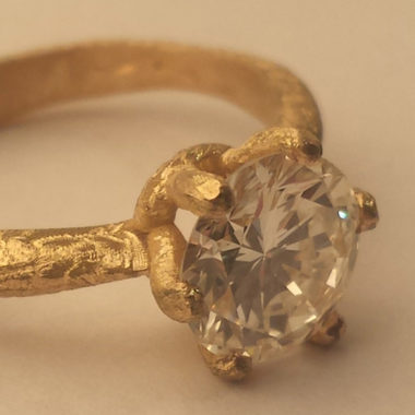 Anello in oro grezzo con diamante fotografato di tre quarti