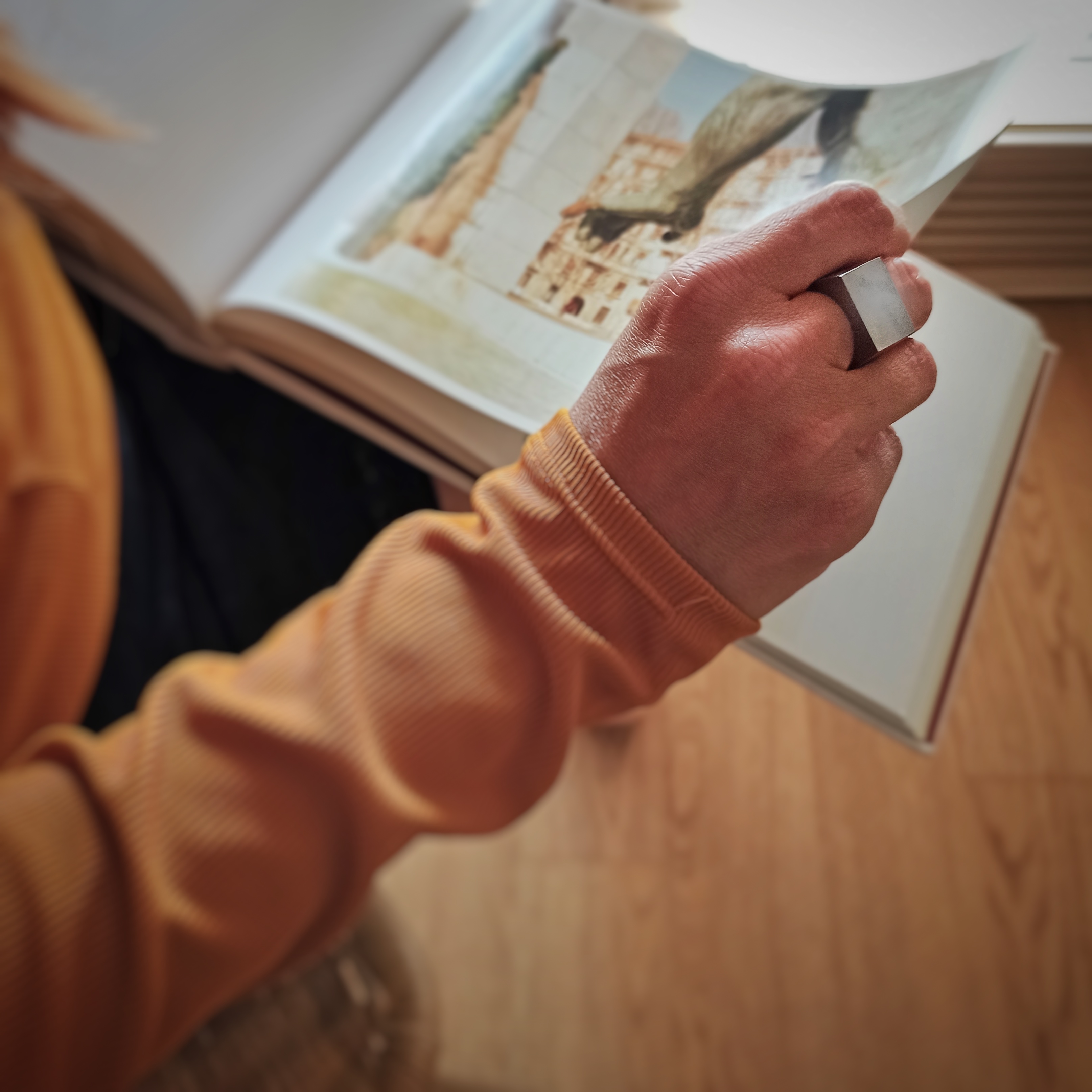 Una donna sfolia un libro di fotografia con un anello Bullone in acciaio