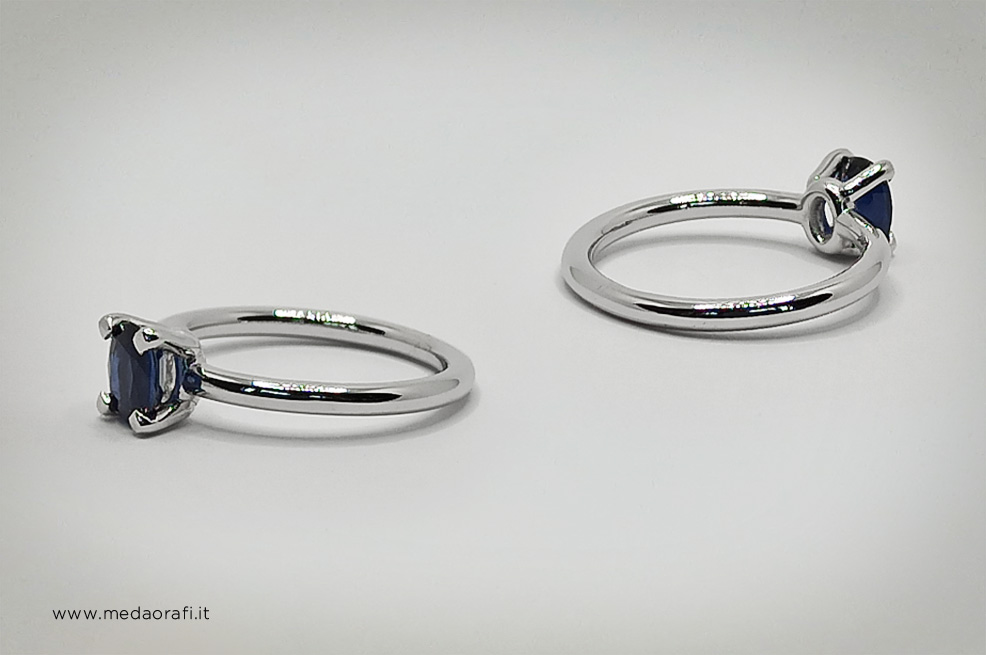 Anello in oro bainco con zaffiro blu, castone frontale e posteriore