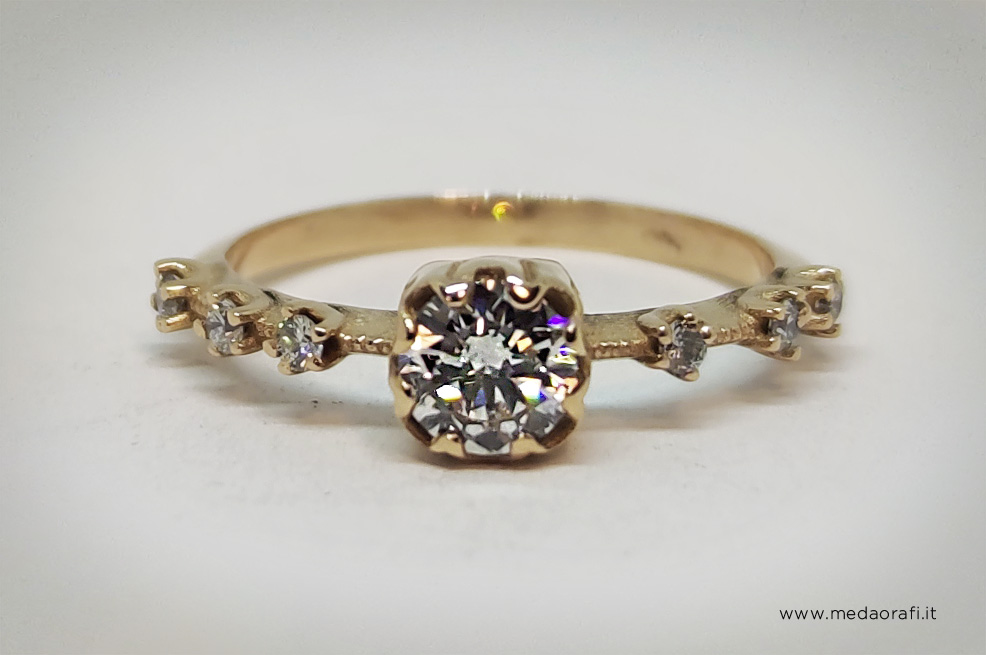 Anello con diamante centrale e brillanti laterali sul gambo