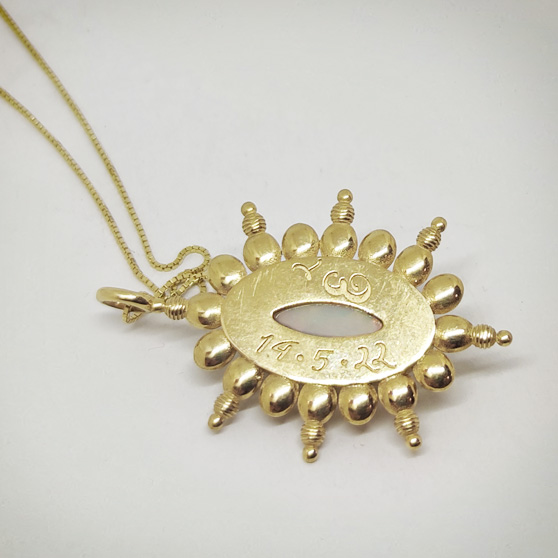 Retro di un pendente in oro e opale, con incisioni