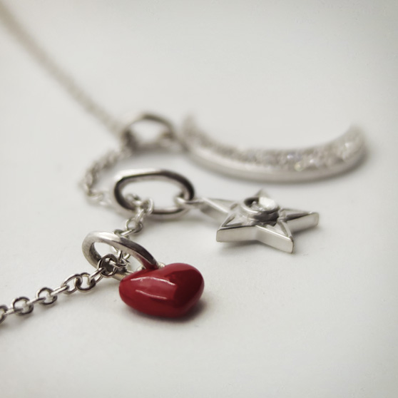 Pendenti in oro bianco e brillanti, in primo piano un cuore smaltato in rosso
