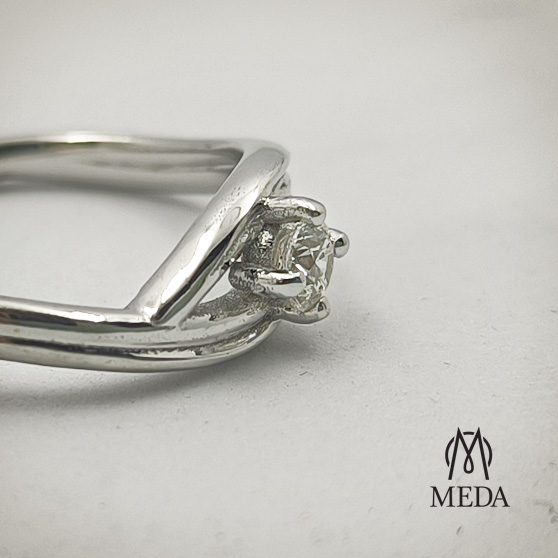 Anello di fidanzamento su disegno in oro bianco e diamante, dettaglio del castone e delle griffes