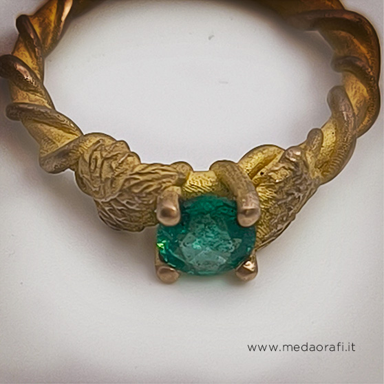 Anello artigianale in oro con gambo a forma di tralcio di vite e foglie, pietra centrale smeraldo